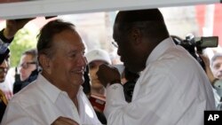 Felipe Valls toma un cafecito cubano en el Versailles junto al entonces candidato presidencial republicano Herman Cain, en 2011. (AP/Lynne Sladky/Archivo)