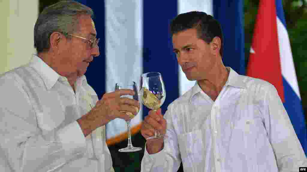 El presidente de México Enrique Peña Nieto y su homólogo cubano, Raúl Castro, brindan tras una rueda de prensa conjunta.