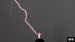 Vista de un rayo que cae en la mano derecha de la estatua del Cristo Redentor, el jueves 16 de enero de 2014, en la ciudad de Río de Janeiro (Brasil).